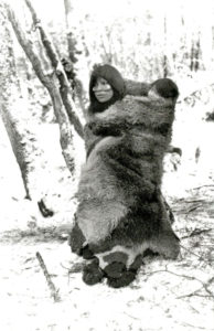 Selknam woman covering her child with a guanaco fur